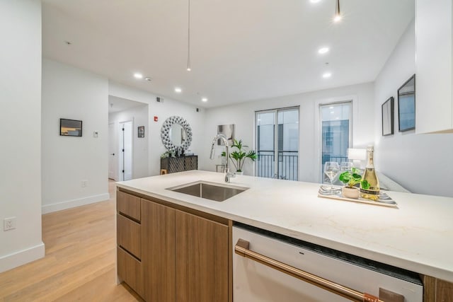 kitchen with light wood-style floors, modern cabinets, brown cabinetry, dishwasher, and a sink