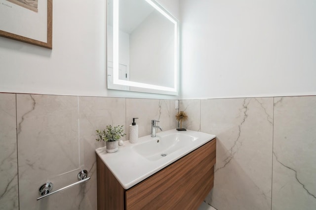 bathroom with tile walls, wainscoting, and vanity