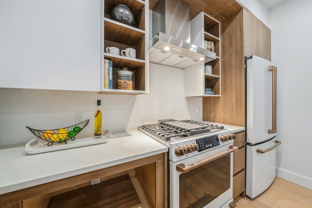 kitchen with open shelves, wall chimney range hood, freestanding refrigerator, brown cabinets, and gas stove