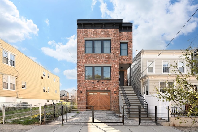 77 Clerk St Unit 1, Jersey City, NJ 07305 - view of front of home with a garage, fence private yard, brick siding, and a gate