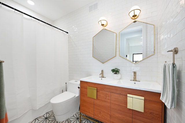 77 Clerk St Unit 1, Jersey City, NJ 07305 - bathroom featuring tasteful backsplash, tile walls, double vanity, toilet, and visible vents