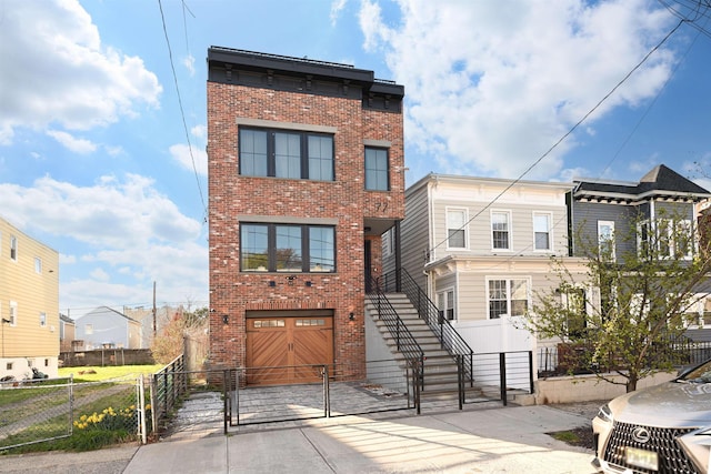 77 Clerk St Unit 1, Jersey City, NJ 07305 - view of property with brick siding, an attached garage, driveway, and a gate