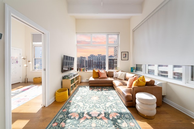 1500 Hudson St Unit 7R, Hoboken, NJ 07030 - living room featuring healthy amount of natural light, wood finished floors, beamed ceiling, and a view of city