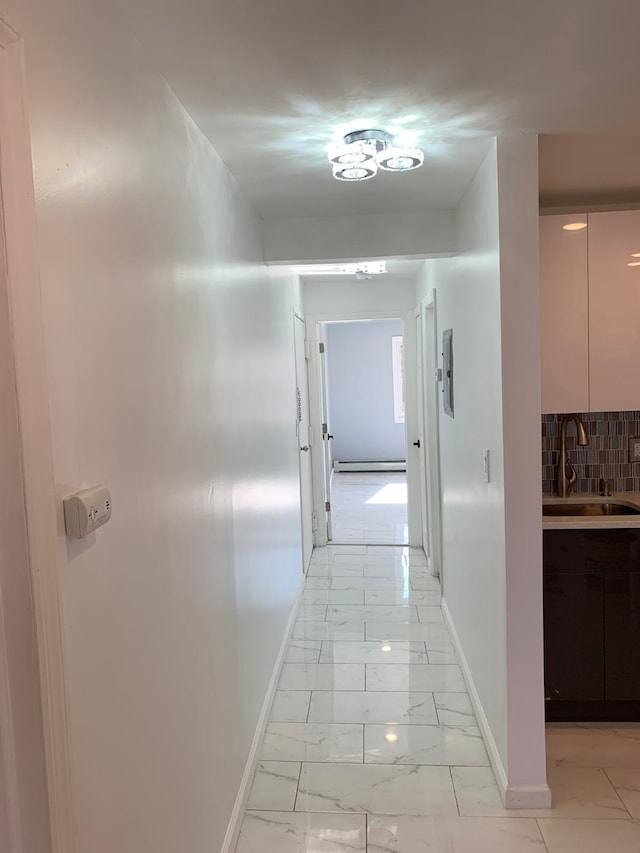 1604 74th St Unit 202, North Bergen, NJ 07047 - hallway with a sink, light marble finish floors, baseboards, and a baseboard radiator