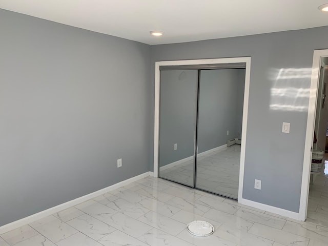 1604 74th St Unit 202, North Bergen, NJ 07047 - unfurnished bedroom featuring light marble finish flooring, baseboards, a closet, a baseboard radiator, and recessed lighting