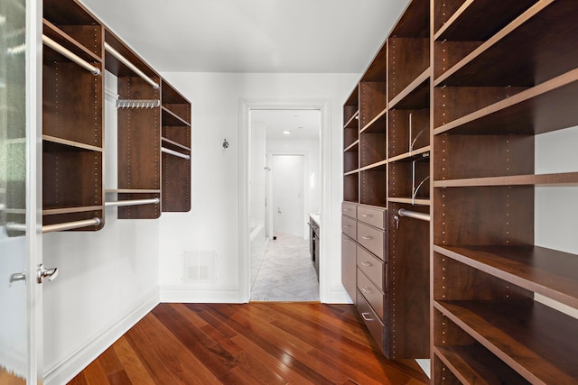 walk in closet featuring dark wood-type flooring