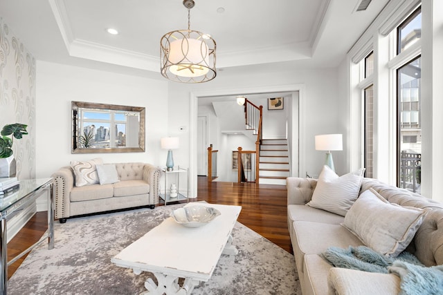 living room featuring ornamental molding, hardwood / wood-style floors, and a tray ceiling