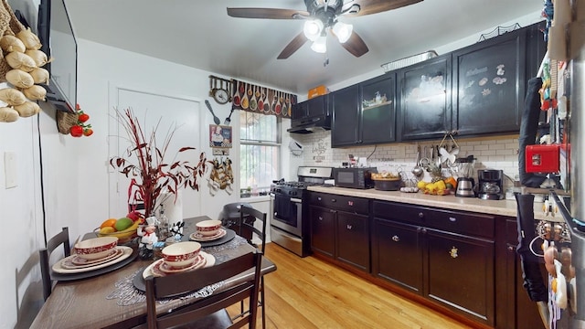 kitchen with light wood-type flooring, ceiling fan, tasteful backsplash, and gas stove