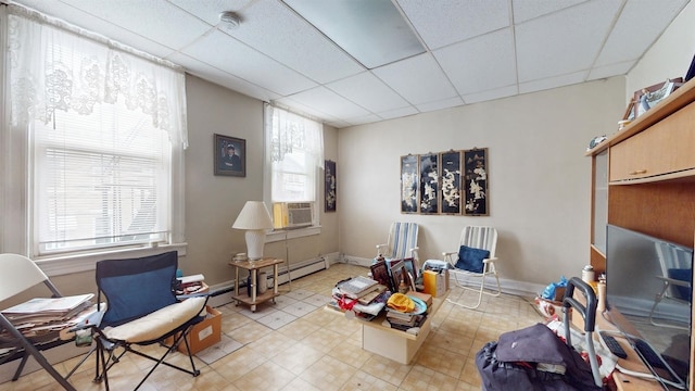 living area with a wealth of natural light and a paneled ceiling