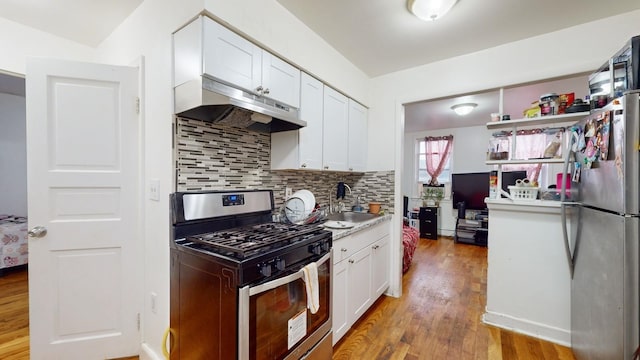 kitchen with white cabinetry, sink, light wood-type flooring, and appliances with stainless steel finishes