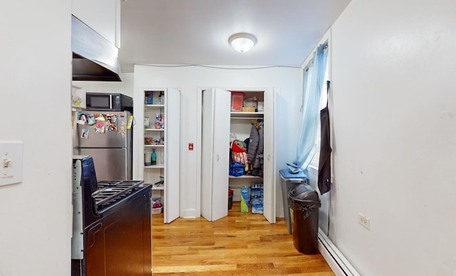 kitchen featuring light wood-type flooring and black appliances