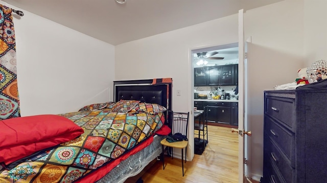 bedroom with connected bathroom and light hardwood / wood-style flooring