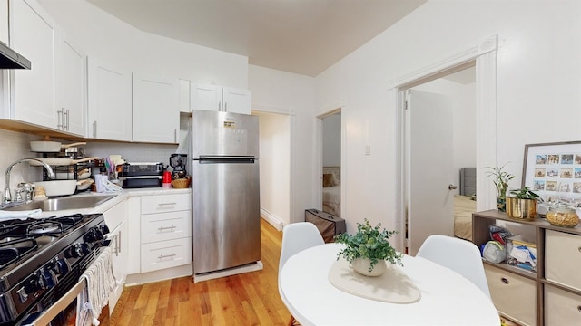 kitchen featuring white cabinets, sink, light hardwood / wood-style floors, and stainless steel appliances