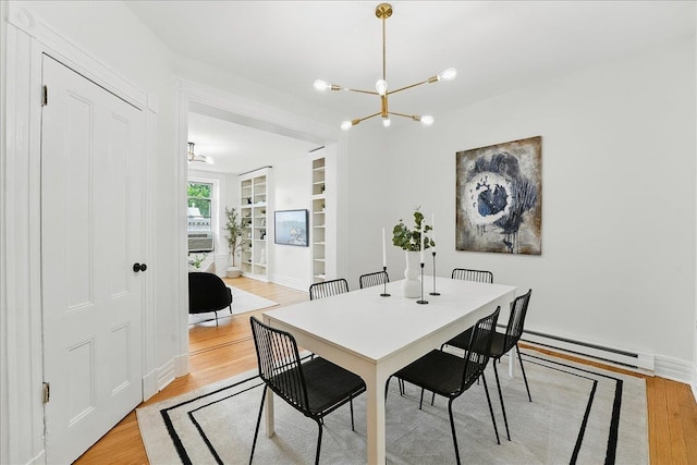 821 Washington St Unit 5, Hoboken, NJ 07030 - dining area with a baseboard heating unit, light wood-style flooring, and a chandelier