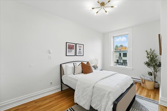 821 Washington St Unit 5, Hoboken, NJ 07030 - bedroom with a chandelier, light wood-style floors, and a baseboard heating unit