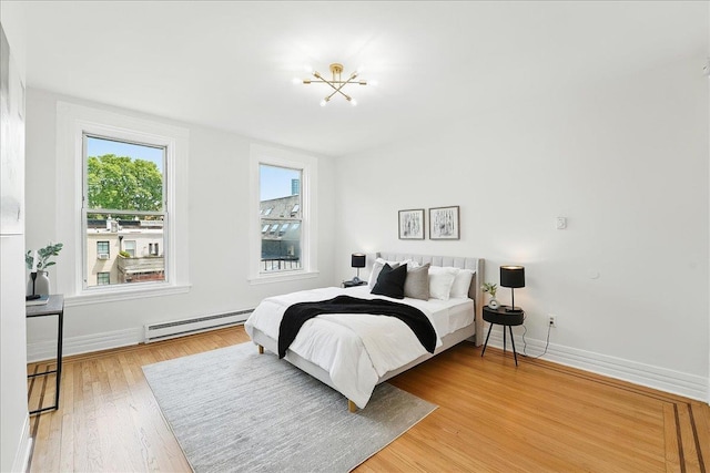 821 Washington St Unit 5, Hoboken, NJ 07030 - bedroom featuring a baseboard heating unit, a chandelier, and light wood-style floors
