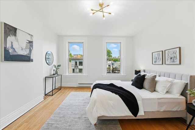 821 Washington St Unit 5, Hoboken, NJ 07030 - bedroom featuring a baseboard radiator, wood finished floors, and a chandelier