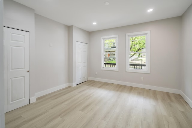 unfurnished bedroom featuring light wood-type flooring, baseboards, and recessed lighting