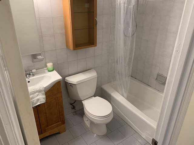 full bathroom with toilet, shower / tub combo, vanity, tile walls, and tile patterned floors