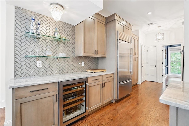 324 Hudson St # 1, Hoboken, NJ 07030 - kitchen with wine cooler, stainless steel built in refrigerator, a chandelier, backsplash, and light wood-style flooring