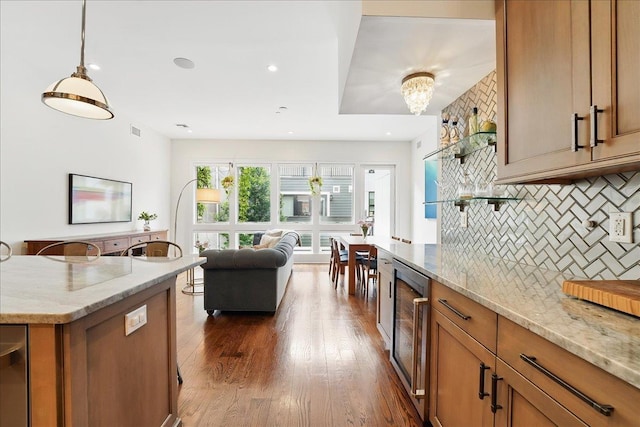 324 Hudson St # 1, Hoboken, NJ 07030 - kitchen featuring wine cooler, brown cabinetry, tasteful backsplash, and light stone counters
