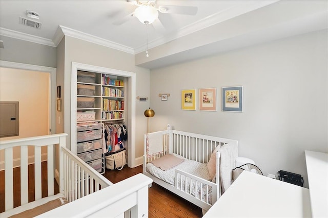 324 Hudson St # 1, Hoboken, NJ 07030 - bedroom with crown molding, wood finished floors, electric panel, a crib, and a ceiling fan