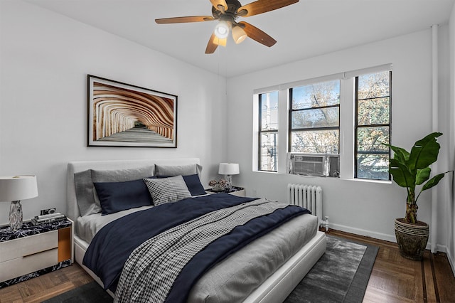 bedroom with ceiling fan, radiator, and dark parquet floors