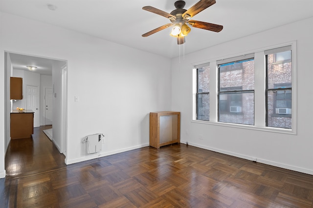 unfurnished room featuring ceiling fan and dark parquet floors