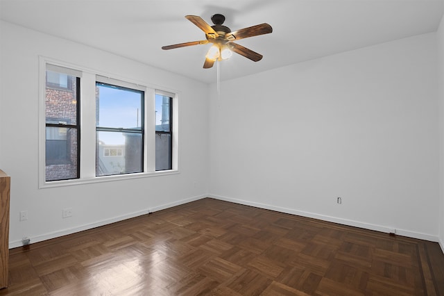 spare room with dark parquet flooring and ceiling fan