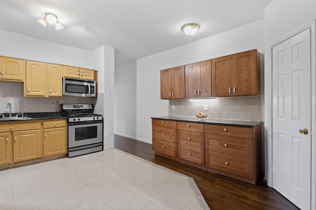 179 Manhattan Ave Unit 3B, Jersey City, NJ 07307 - kitchen featuring appliances with stainless steel finishes, dark countertops, decorative backsplash, and a sink