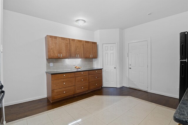 179 Manhattan Ave Unit 3B, Jersey City, NJ 07307 - kitchen featuring brown cabinets, tile patterned flooring, decorative backsplash, and baseboards