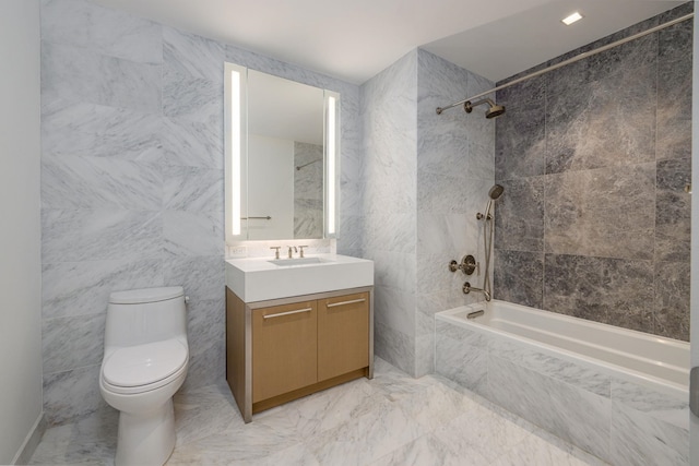 full bathroom featuring toilet, vanity, tile walls, and tiled shower / bath