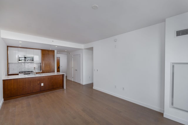 unfurnished living room with sink and wood-type flooring