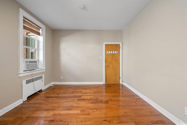 101 Kensington Ave Unit A1, Jersey City, NJ 07304 - unfurnished room featuring radiator heating unit, wood finished floors, cooling unit, and a smoke detector
