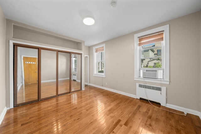 101 Kensington Ave Unit A1, Jersey City, NJ 07304 - unfurnished bedroom with radiator, cooling unit, light wood-type flooring, and a closet