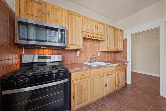 101 Kensington Ave Unit A1, Jersey City, NJ 07304 - kitchen with stainless steel appliances, tile countertops, tasteful backsplash, light brown cabinetry, and dark tile patterned flooring