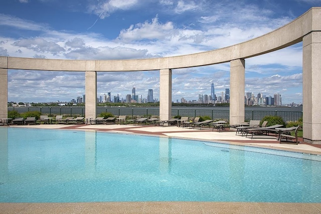 pool featuring a view of city, fence, and a patio