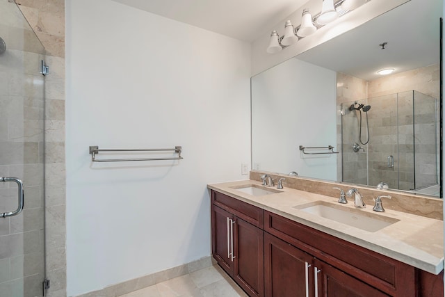full bathroom with a sink, baseboards, a stall shower, and double vanity