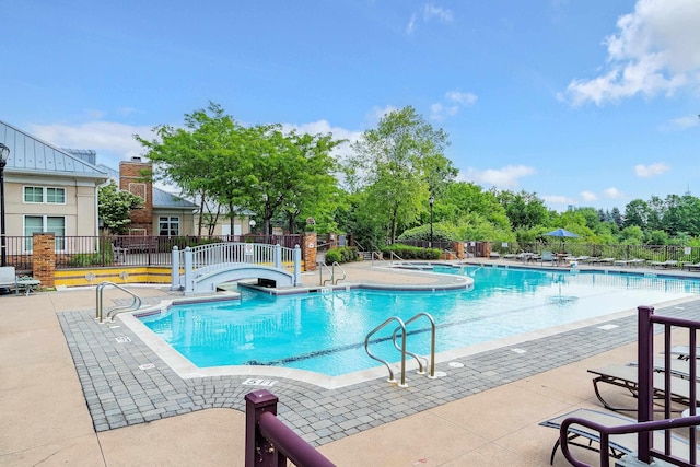 pool with a patio and fence