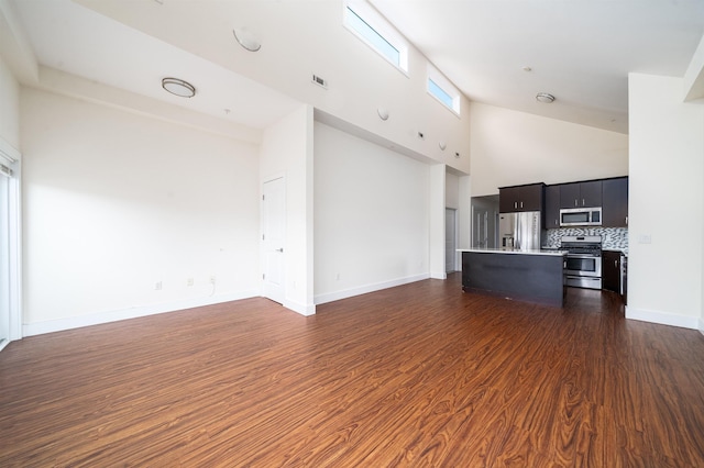 308 18th St, Union City, NJ 07087 - unfurnished living room featuring baseboards, a high ceiling, visible vents, and dark wood-type flooring
