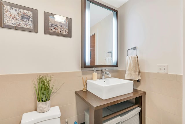 601 Observer Hwy Unit 204, Hoboken, NJ 07030 - bathroom featuring a sink, tile walls, toilet, and wainscoting