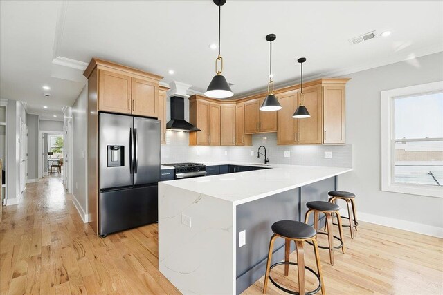 181 Bartholdi Ave Unit 2, Jersey City, NJ 07305 - kitchen with stainless steel fridge, wall chimney range hood, a peninsula, backsplash, and light wood-style floors