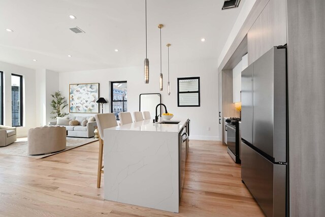 262 Webster Ave Unit 2, Jersey City, NJ 07307 - kitchen featuring appliances with stainless steel finishes, modern cabinets, a breakfast bar area, light wood-style flooring, and recessed lighting