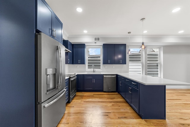 kitchen with sink, hanging light fixtures, light wood-type flooring, appliances with stainless steel finishes, and kitchen peninsula