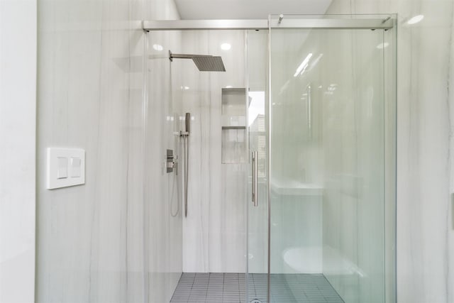 bathroom featuring a shower with shower door