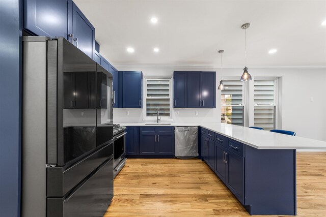 kitchen featuring decorative light fixtures, sink, kitchen peninsula, and stainless steel appliances