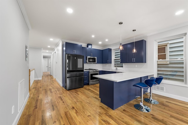 kitchen with kitchen peninsula, appliances with stainless steel finishes, light wood-type flooring, blue cabinets, and a breakfast bar area