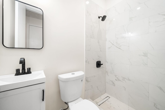 bathroom with vanity, toilet, and a tile shower