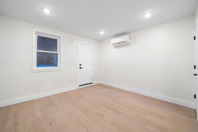 empty room featuring light hardwood / wood-style flooring and an AC wall unit