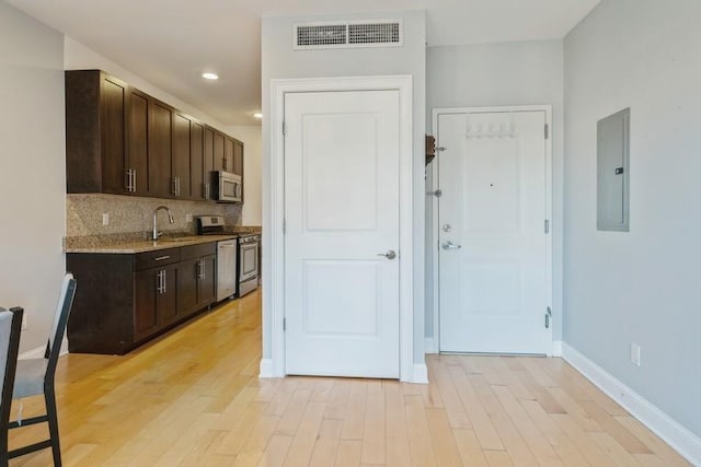 112 Liberty View Dr Unit 4B, Jersey City, NJ 07302 - kitchen with appliances with stainless steel finishes, electric panel, dark brown cabinetry, light wood-type flooring, and recessed lighting